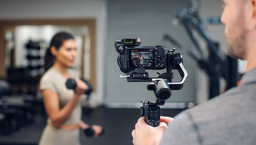 System mikrofonów bezprzewodowych DJI Mic 3 2 TX + 2 RX + Etui ładujące czarny grafika przedstawia mężczyznę nagrywającego kobietę na siłowni